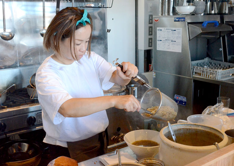 厨房でラーメンを作る仲松店長。「他のラーメン店と比べて使う煮干しの量は断然多いと思う」と話す＝九十九里町