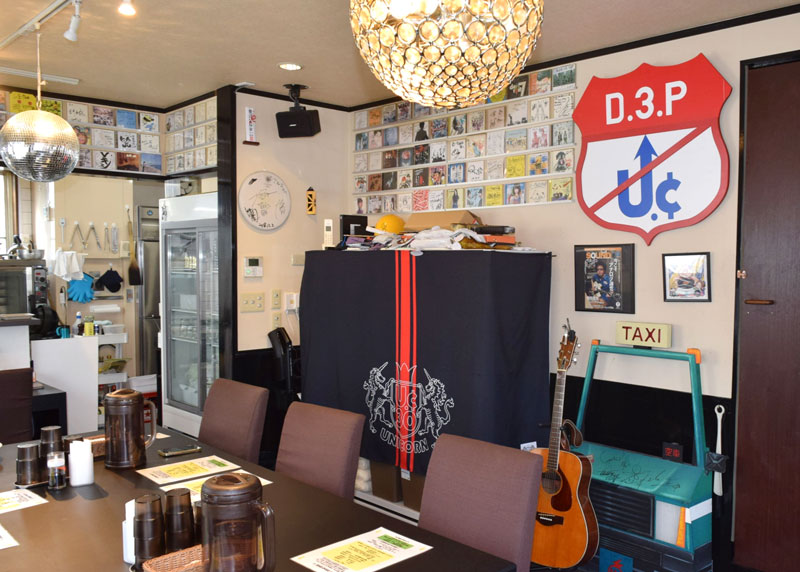 サイン入りＣＤが飾られた「ｅ－ｔｗｏ」の店内。壁際にユニコーンがコンサートで使った小道具が置かれている