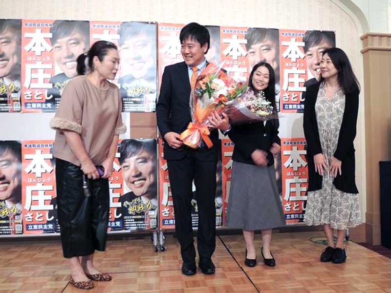 選挙スタッフから花束を受け取り笑顔を見せる立憲民主党の本庄氏=27日、柏市