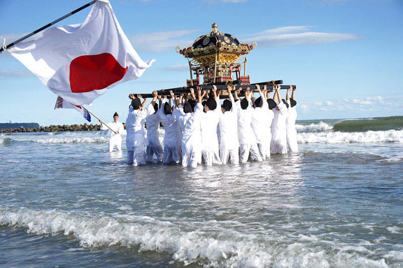 海に漬かりながら息を合わせてみこしを上げる若者ら=7日、旭市