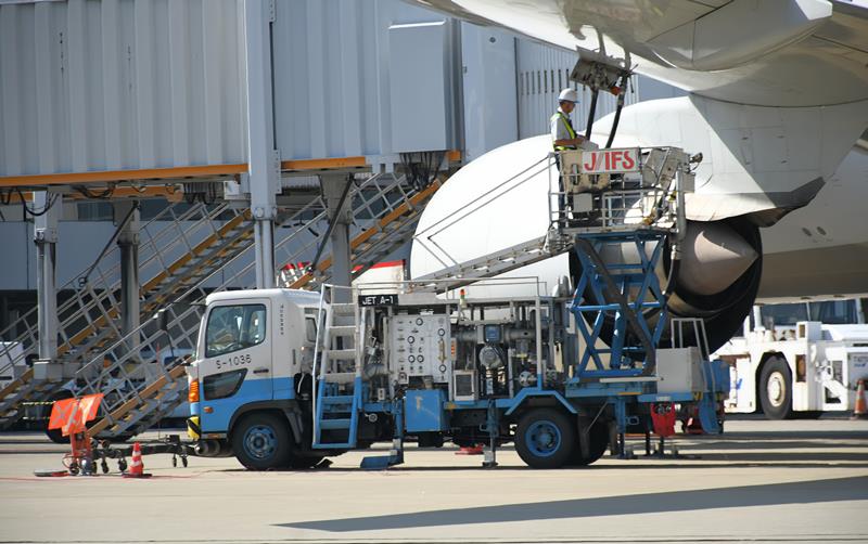 成田空港で特殊車両を介して燃料を給油される航空機=8月、成田市