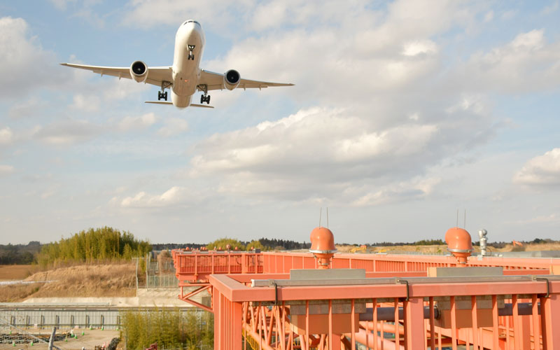 延伸予定のB滑走路に向けて着陸態勢に入る航空機。手前の進入灯橋梁の直線に沿って延伸部分が整備される