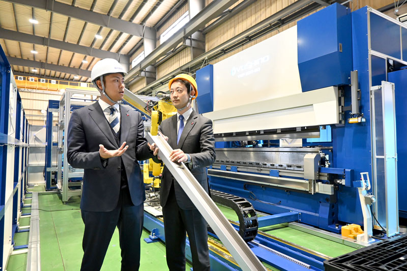 熊谷俊人知事(右)が視察に訪れ、新製品について解説する吉野友章CEO=2024年12月12日、千葉市緑区の吉野機械製作所第1工場