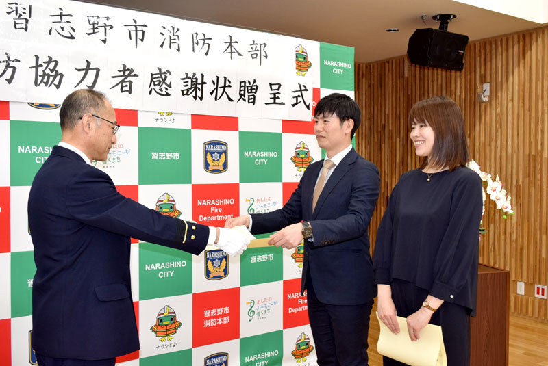 鈴木消防長（左）から感謝状を贈られる鈴木夫妻＝習志野市