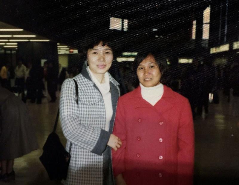 日本に到着、花崎みさを（左）が用意した赤いコートを着るテュイ＝１９８１年３月、成田空港（テュイさん提供）（共同）