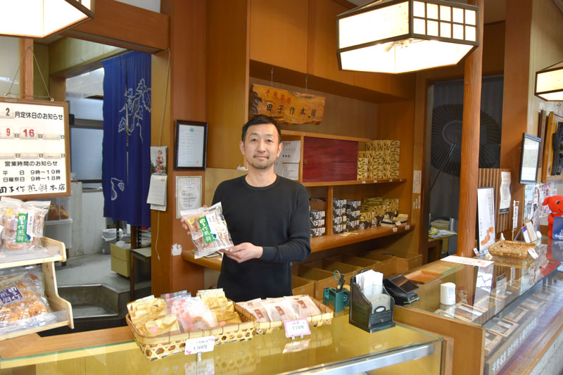 商品を手に今後の事業展開を話す長島淳一専務