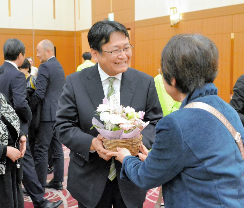当選が確実になり、支持者から祝福を受ける神谷氏(中央)=16日、千葉市中央区