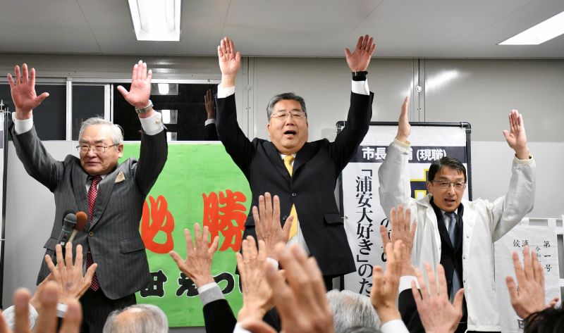 浦安市長選で無投票3選を決め、万歳する内田氏(中央)=9日、浦安市
