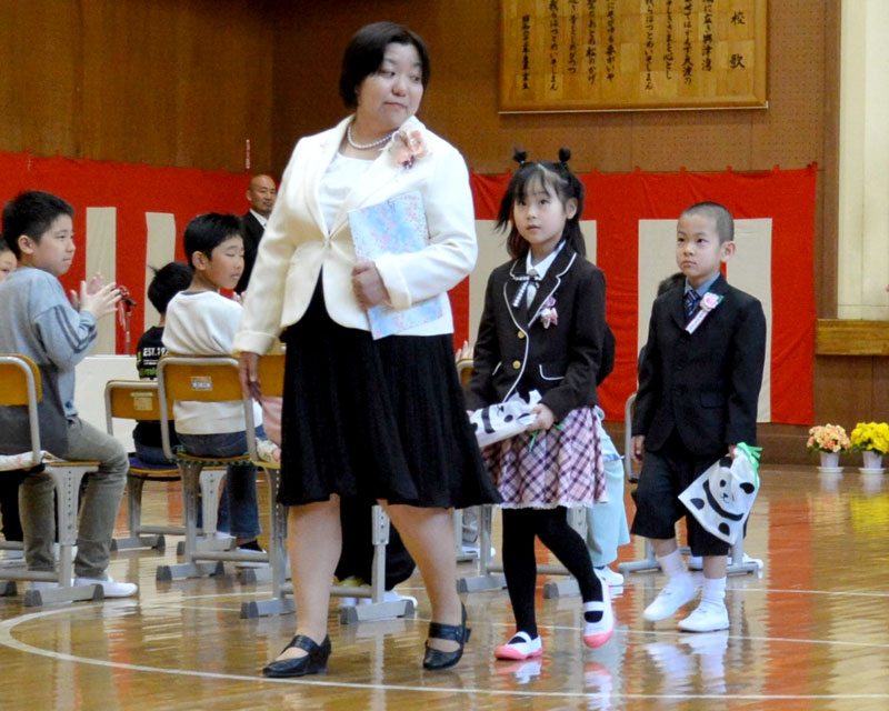 勝浦市立興津小の入学式に出席した新１年生の２人。在校生１３人が温かく迎えた＝９日、勝浦市
