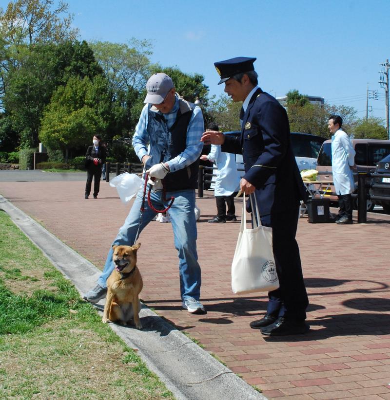 愛犬を連れて「わんわんパトロール」の案内チラシを受け取る飼い主＝１４日、市原市のちはら台公園