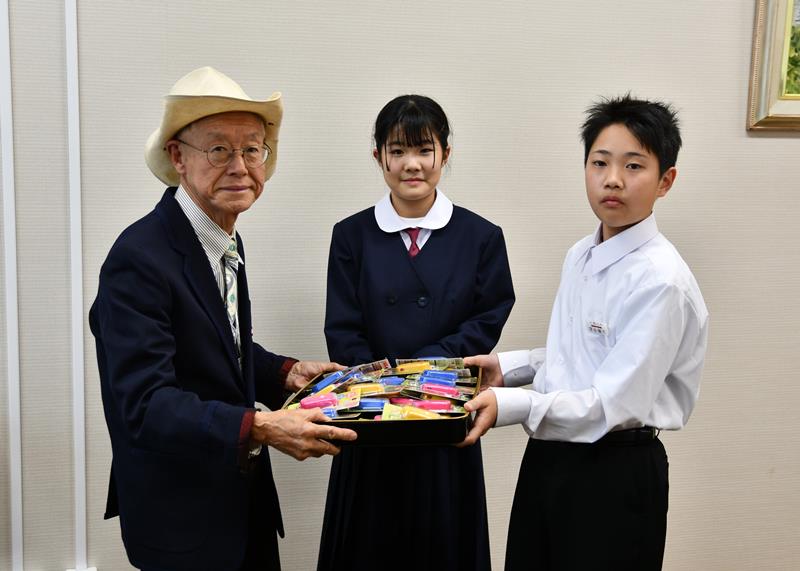 小見川中の新入生に防犯ブザーを贈った小山田会長（左）＝香取市