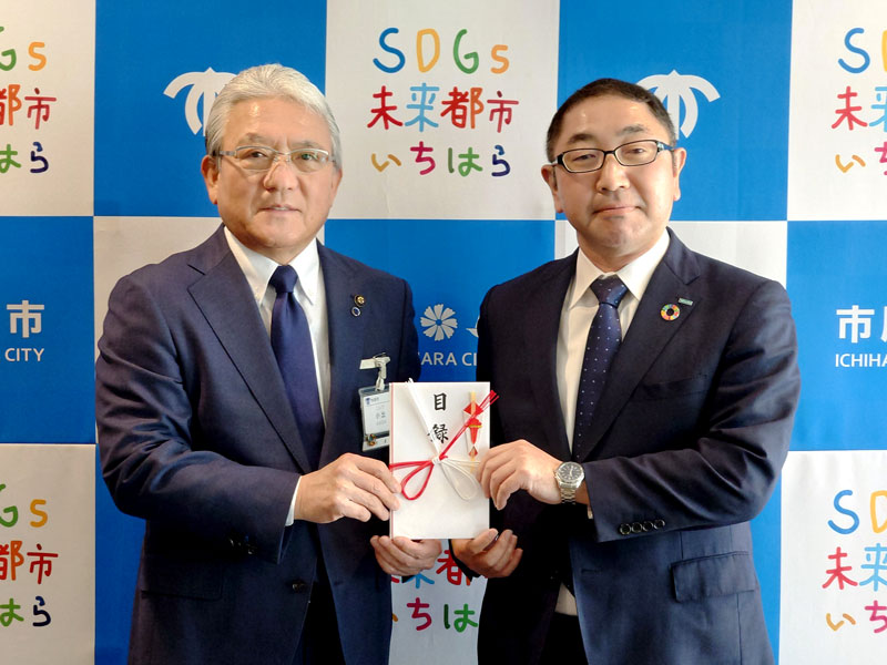 小出譲治市原市長（左）に目録を手渡す坂井支店長＝市原市役所
