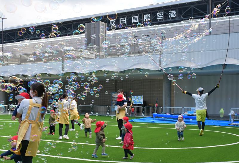 ポポパークの人工芝の園庭で楽しそうに走り回る園児ら=成田市の成田空港