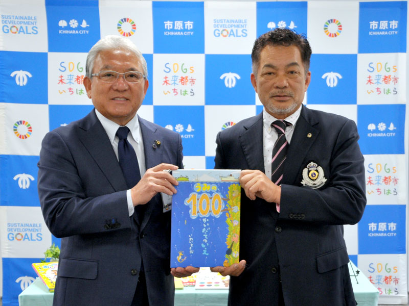 小山会長（右）から絵本の寄贈を受ける小出市長＝１日、市原市役所
