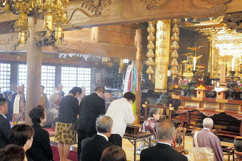 先祖法要で静かに手を合わせる参列者=6日、銚子市