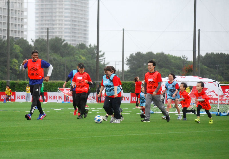 歩いてサッカーを楽しむ鈴木選手ら