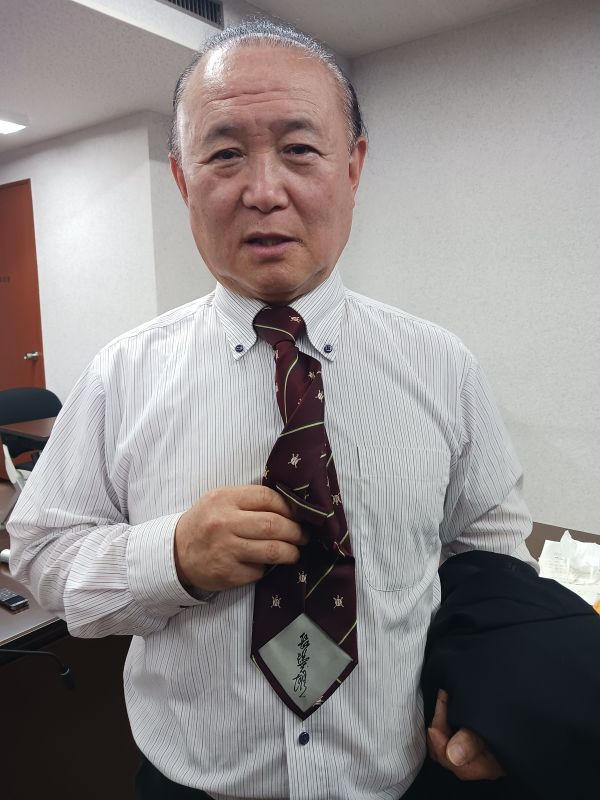 長嶋茂雄さんのサインが印字されたネクタイを着用し、取材に応じるプリティ長嶋県議=3日、県議会