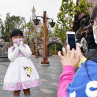 「美女と野獣」の世界が広がる新エリアの前で記念撮影する子ども＝２５日、浦安市
