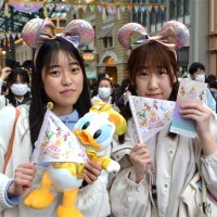 ミッキーマウスの耳がついたカチューシャやぬいぐるみなど４０周年の記念グッズを購入したゲスト